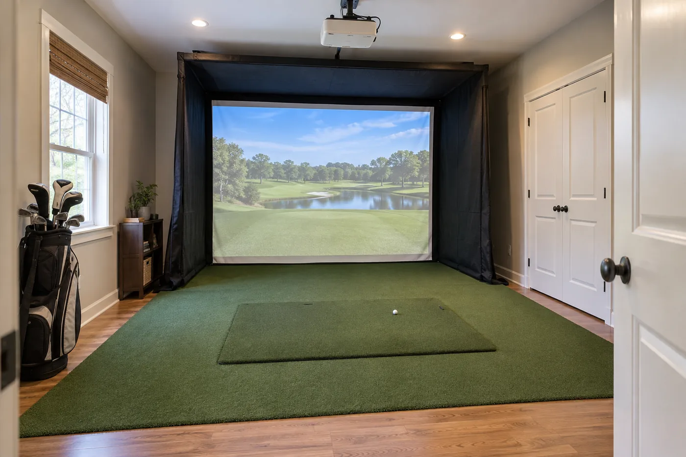 Spare-room golf simulator with a simple enclosure and practical turf area
